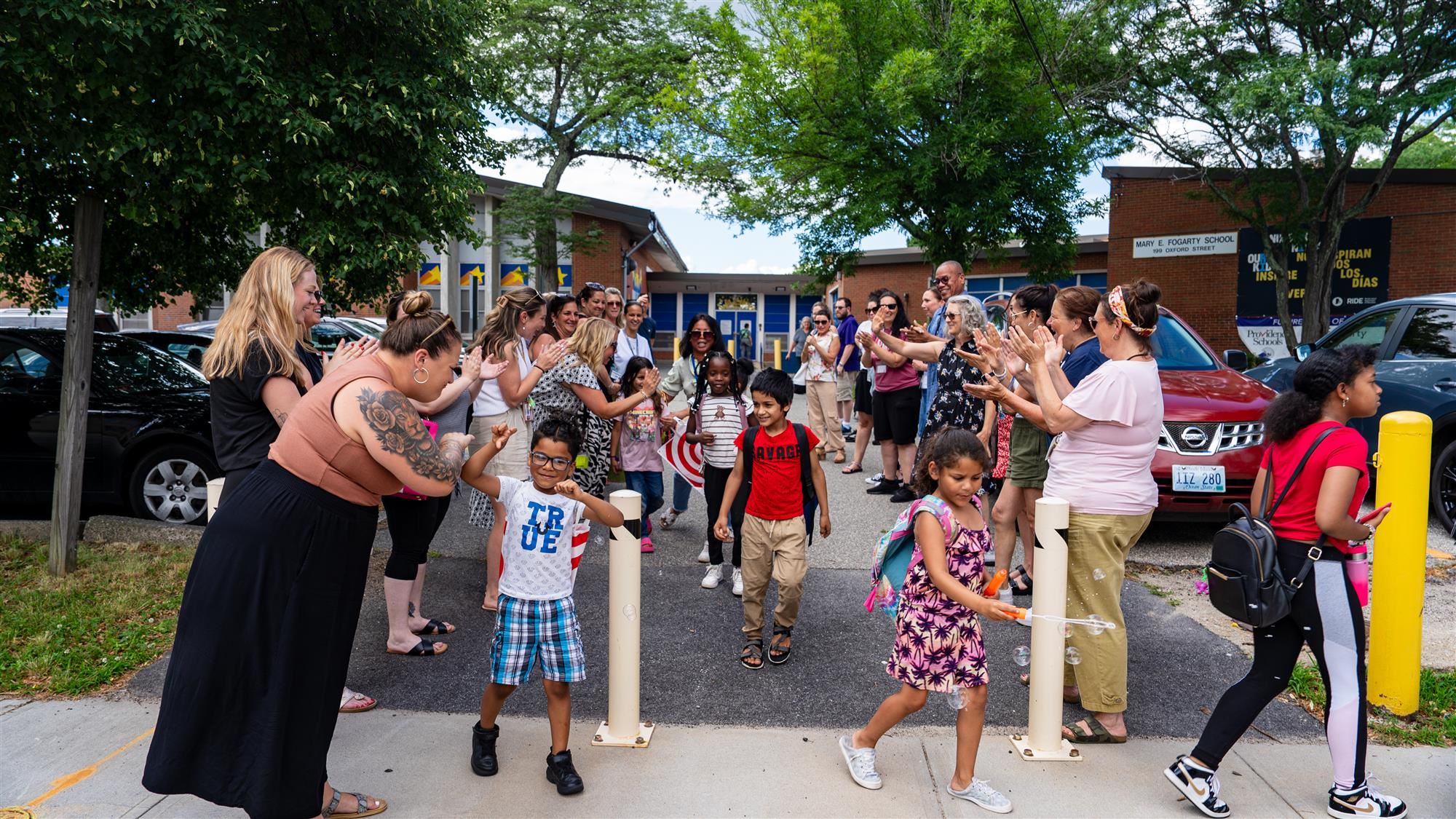 Fogarty Elementary School staff clap for students on the last day